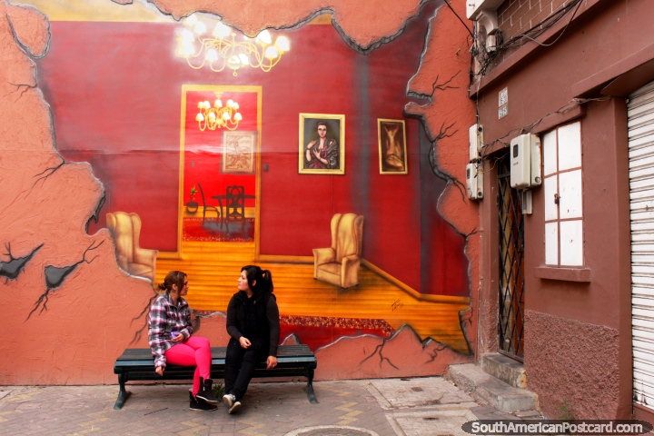 Wall mural of a lounge scene, 2 girls talk in front of it, Ambato. (720x480px). Ecuador, South America.