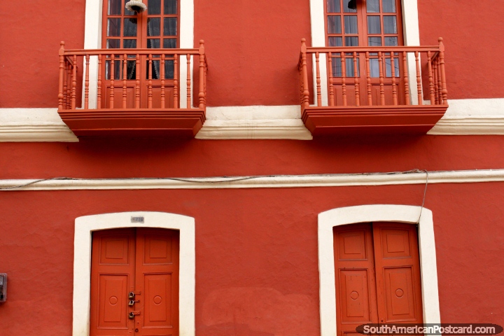 Edifïcio vermelho com balcões vermelhos e portas vermelhas em Guaranda. (720x480px). Equador, América do Sul.