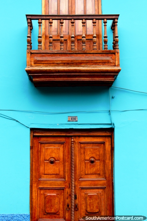 Puerta de madera y balcón puesta sobre una pared azul en Guaranda. (480x720px). Ecuador, Sudamerica.