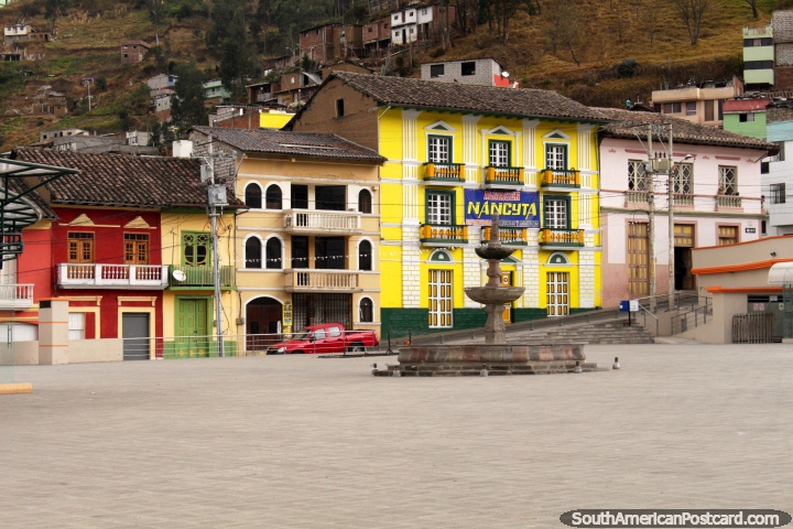 Mirando a través de la Plaza 15 de Mayo hacia un edificio de color amarillo brillante en Guaranda. (720x480px). Ecuador, Sudamerica.