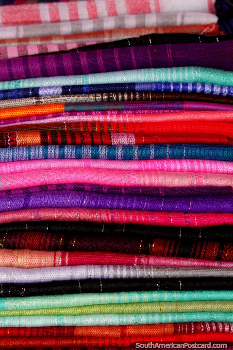 Una pila de material de color a la venta en la Plaza Roja en Riobamba. (480x720px). Ecuador, Sudamerica.