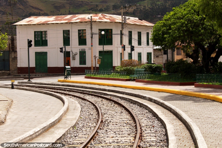 Um edifïcio histórico junto de um parque perto do trem segue a pista em Alausi. (720x480px). Equador, América do Sul.