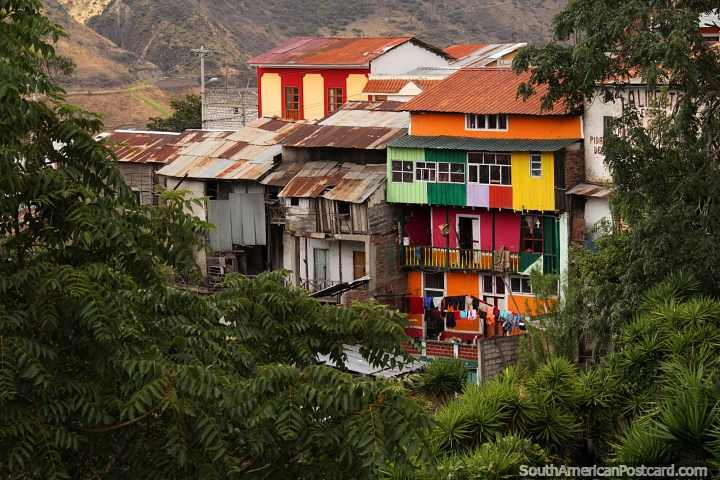 Uma pilha de casas de muitas cores entre a cidade e a ponte em Alausi. (720x480px). Equador, América do Sul.