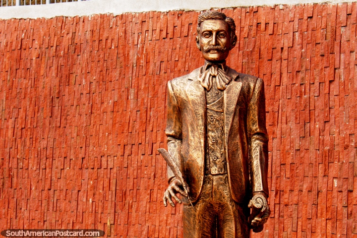 Homem com uma caneta e papel, uma de 7 estátuas douradas altas na colina em Alausi. (720x480px). Equador, América do Sul.