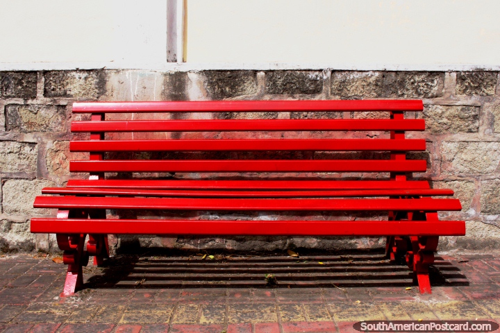 Um banco vermelho-vivo senta-se em de Mayo Plazoleta 24 em Alausi. (720x480px). Equador, América do Sul.