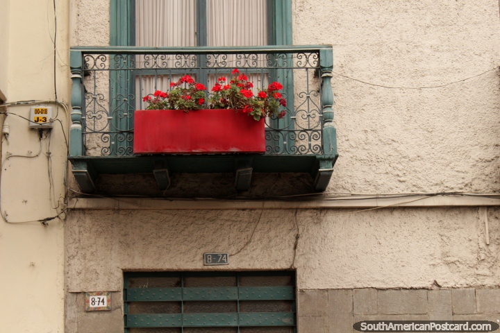 Wooden and iron balcony with red flowers in Cuenca, a city of many balconies with flowers. (720x480px). Ecuador, South America.