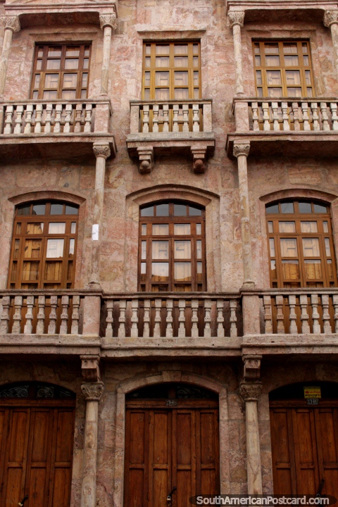 Uma fachada de pedra marrom com portas de madeira e janelas em Cuenca. (480x720px). Equador, Amrica do Sul.