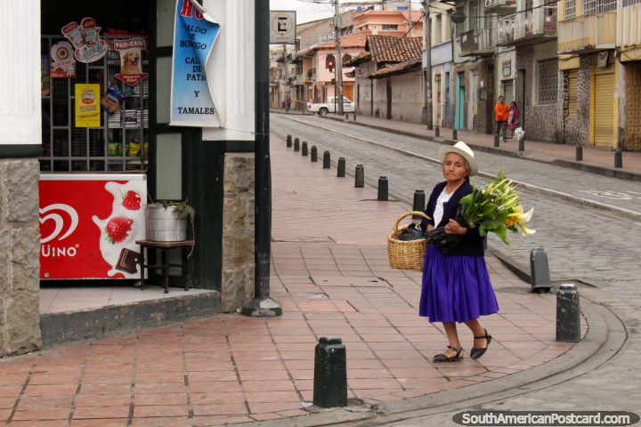 Una mujer que llevaba un sombrero blanco lleva flores a lo largo de la calle en Cuenca. (720x480px). Ecuador, Sudamerica.