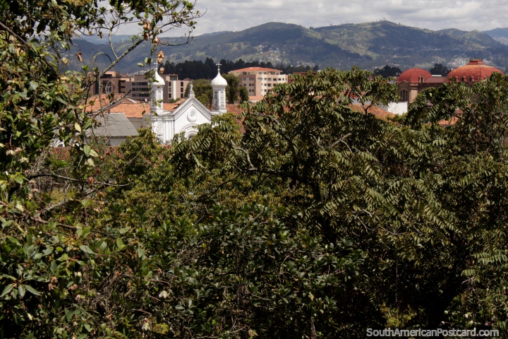 Vista de una iglesia y el techo de un colegio con las colinas distantes en Cuenca. (720x480px). Ecuador, Sudamerica.