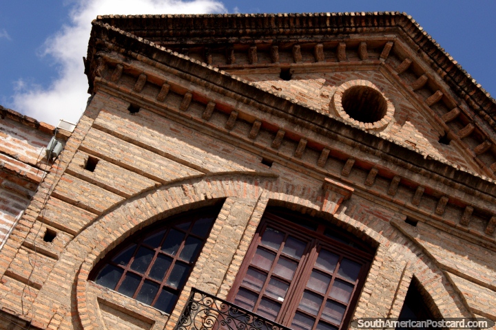 Fachada de tijolo com uma portinhola e janelas arredondadas em Cuenca. (720x480px). Equador, Amrica do Sul.