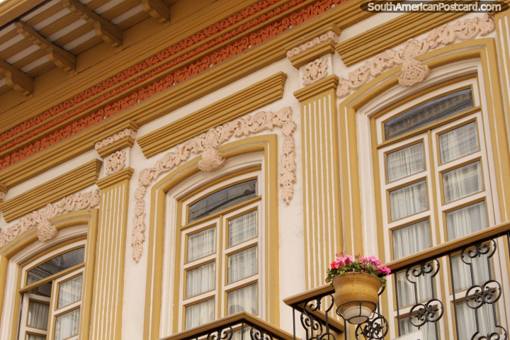 Nice gold facade and windows with pink flowers in a pot, Cuenca. (720x480px). Ecuador, South America.