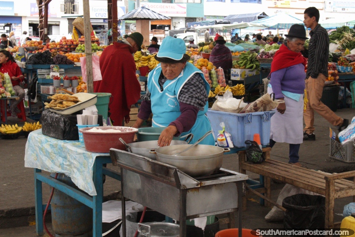 Una mujer cocina al lado de la de frutas y verduras en el mercado de Pujil. (720x480px). Ecuador, Sudamerica.