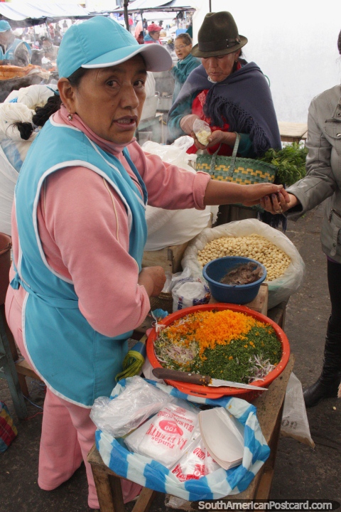 A woman prepares chopped vegetables for cooking at the market in Pujili. (480x720px). Ecuador, South America.