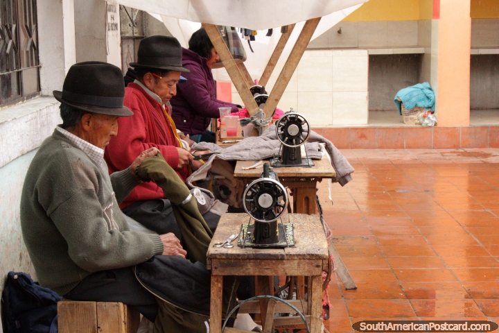 2 men do clothes repairs with sewing machines in the street in Saquisili. (720x480px). Ecuador, South America.