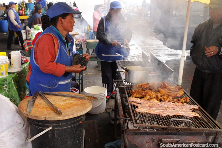 A woman barbecues chicken feet at Plaza Gran Colombia in Saquisili. (720x480px). Ecuador, South America.