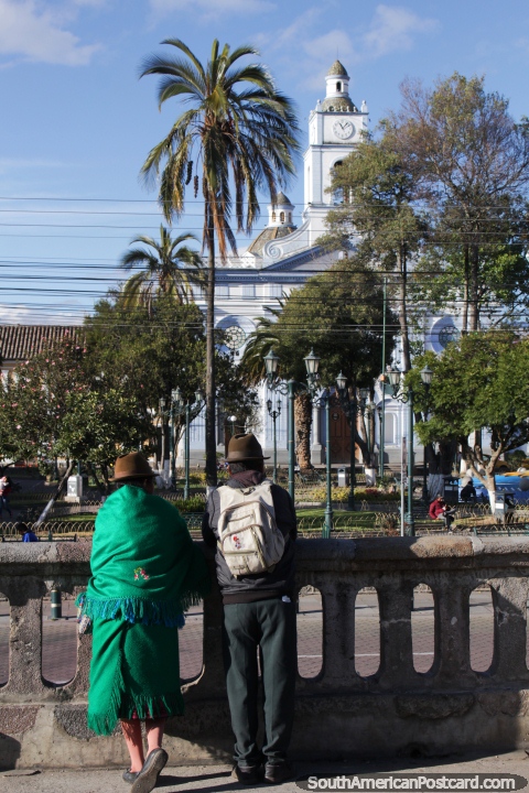 Um par de habitantes locais de Cayambe admira o parque e igreja. (480x720px). Equador, América do Sul.