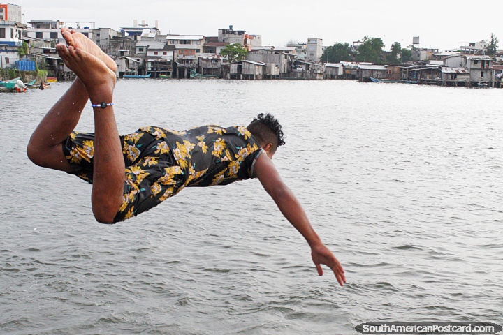 O jovem voa na água depois de saltar do cais em San Lorenzo. (720x480px). Equador, América do Sul.