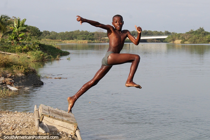 Um pulo gigantesco da humanidade, o rapaz jovem pula no rio em Esmeraldas. (720x480px). Equador, Amrica do Sul.
