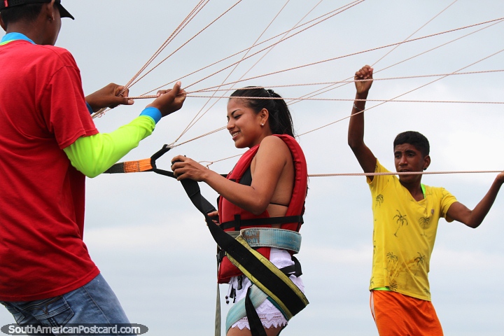 Girl gets rigged up and ready to go parasailing in Atacames. (720x480px). Ecuador, South America.