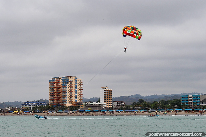 View of Atacames beach from the parasailing platform, someone high in the air. (720x480px). Ecuador, South America.