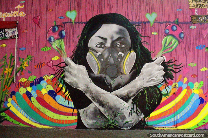 Woman plays shakers in a bed of rainbow colors, awesome street art in Machala. (720x480px). Ecuador, South America.