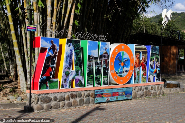 Big Zamora sign near the river with images of local culture and sights, huge bamboo beside. (720x480px). Ecuador, South America.