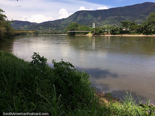 Junto do Rio de Zamora em Yantzaza, ponte distante, águas calmas e colinas verdes. (640x480px). Equador, América do Sul.