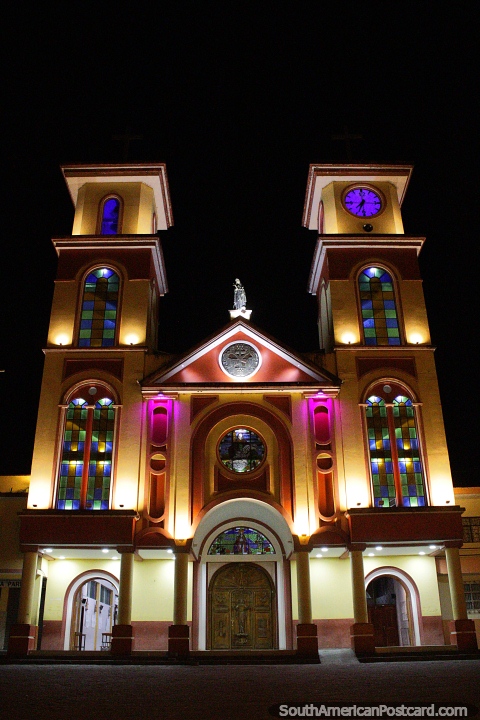 Janelas axadrezadas azuis e verdes, luzes rosa e relógio, a igreja a noite em Yantzaza.  (480x720px). Equador, América do Sul.