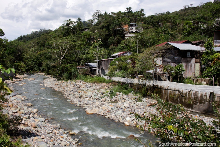 Wooden houses scattered among thick trees on the hillside at the river in Limon. (720x480px). Ecuador, South America.