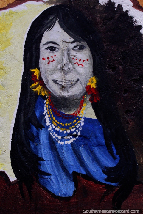 Mujer indígena con pintura facial, flores y collares, arte callejero en Macas. (480x720px). Ecuador, Sudamerica.