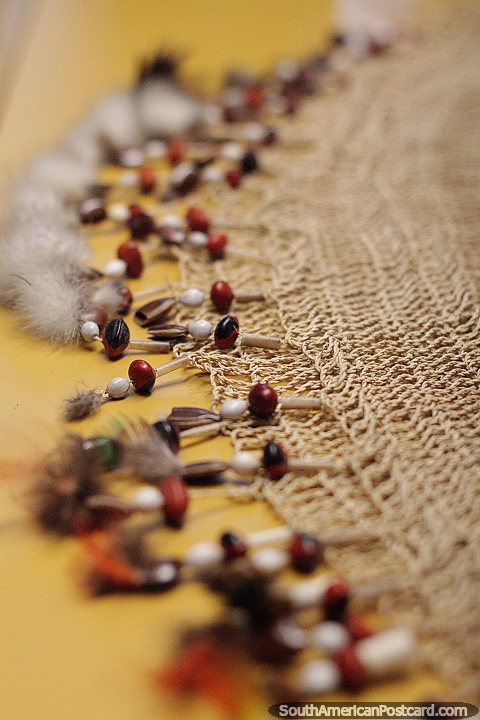 Tecido feito com corda perfeita, sementes e contas em monitor no museu em Puyo. (480x720px). Equador, Amrica do Sul.