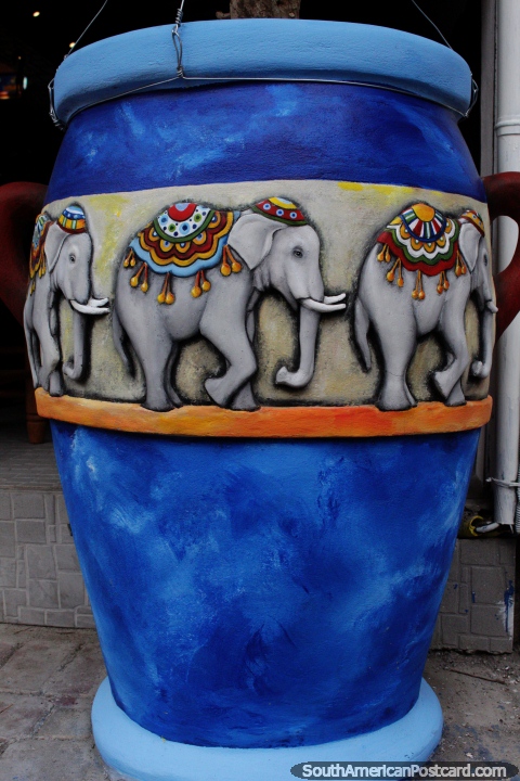 Large blue ceramic vase decorated with images of elephants, colorful streets in Banos. (480x720px). Ecuador, South America.