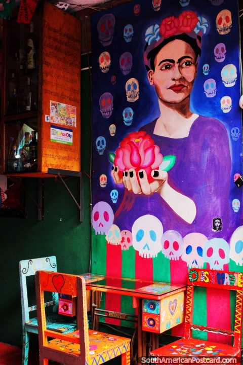 Large purple mural of a woman holding a rose in Banos at Alomeromero Restaurant. (480x720px). Ecuador, South America.