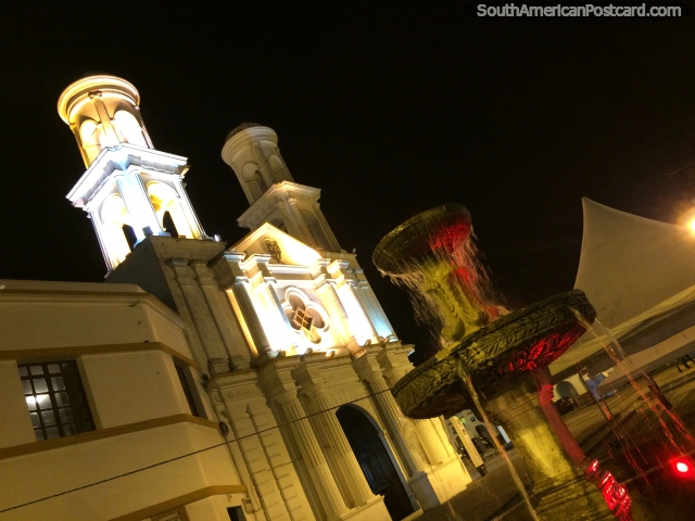 Fonte com luz vermelha em frente de igreja de Santo Domingo em Latacunga a noite. (640x480px). Equador, América do Sul.