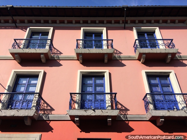 Pink facade in the sun with blue doors and iron balconies, central Quito. (640x480px). Ecuador, South America.
