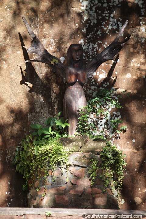 Woman with wings sculpted from a tree on the Walk of Myths in Trinidad. (480x720px). Paraguay, South America.