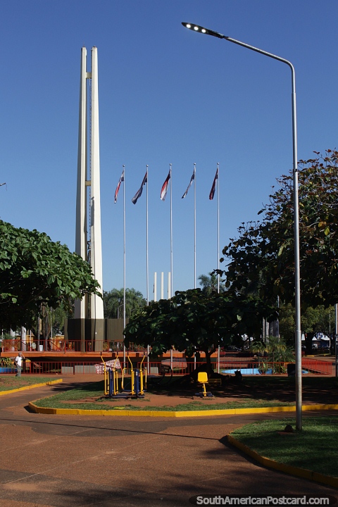Plaza de Armas with monuments and flags in Encarnacion. (480x720px). Paraguay, South America.