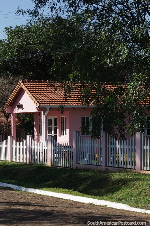 Pink building and fence, nice street in Carmen del Parana. (480x720px). Paraguay, South America.