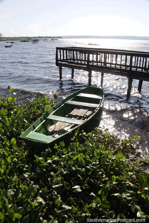 Barco de madera atado a un embarcadero a orillas del lago Ypacarai en Aregua. (480x720px). Paraguay, Sudamerica.