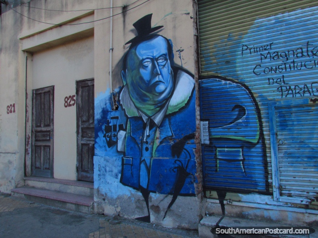 Un hombre azul con sombrero de copa negro, graffiti de la pared y 2 puertas marrones, Asuncin. (640x480px). Paraguay, Sudamerica.