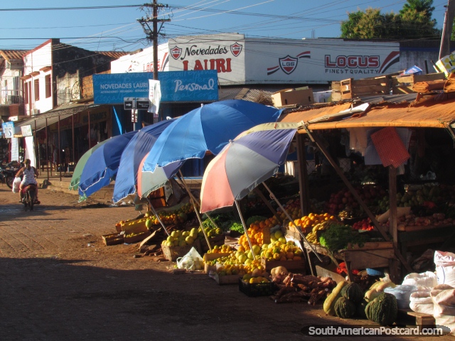 Um estábulo de fruto sombreia-se por guarda-chuvas nos mercados de Concepcion. (640x480px). Paraguai, América do Sul.