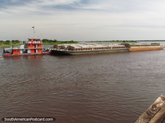 Orange tugboat 'Don Manuel' pushes barge 'Leticia' on the Paraguay River in Concepcion. (640x480px). Paraguay, South America.
