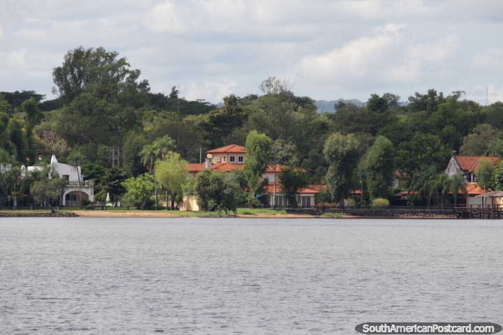 Casas y arbustos de la tierra en el borde del lago en San Bernardino, la escapada de vacaciones. (720x480px). Paraguay, Sudamerica.