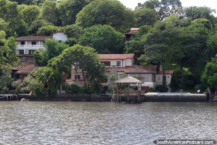 Casas con clase rodeados por arbustos al lado del lago en San Bernardino. (720x480px). Paraguay, Sudamerica.