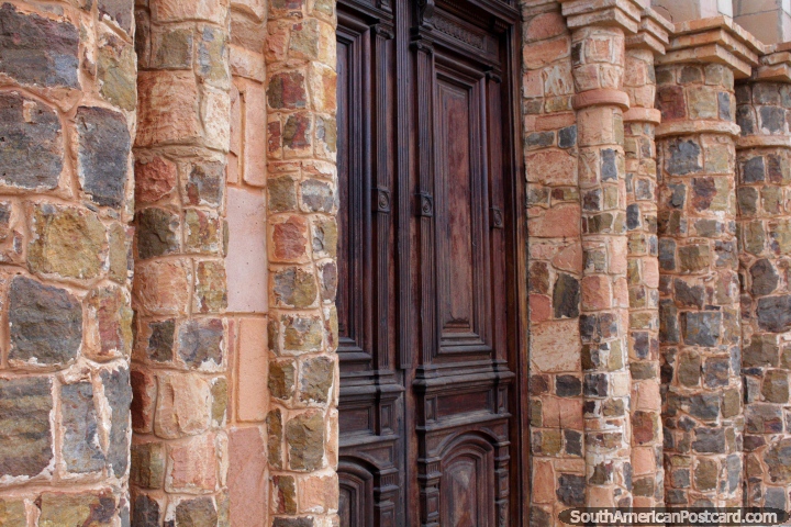 Colunas de pedra em volta da grande porta de madeira em frente de Igreja Ybaroty em Villarrica. (720x480px). Paraguai, Amrica do Sul.