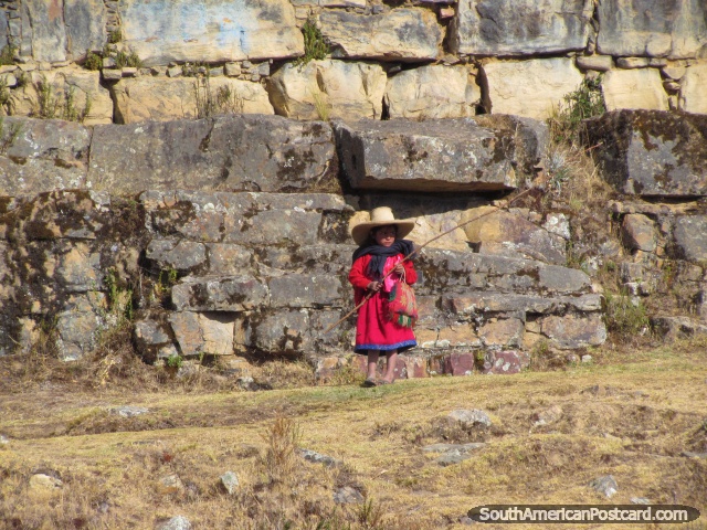 Indigenous girl in pink clothes and falcon hat at Marcahuamachuco. (640x480px). Peru, South America.
