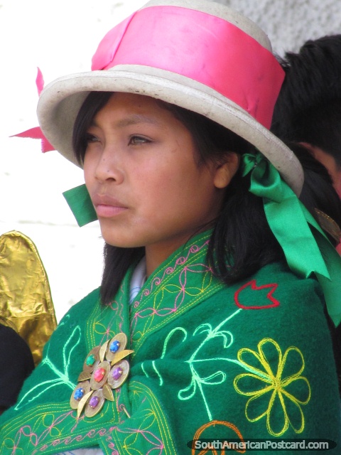 Beautiful young woman in Huaraz with white hat, pink ribbon and green shawl with flowers. (480x640px). Peru, South America.