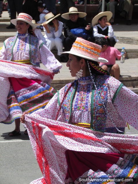 2 women in traditional dresses dance in a Huaraz street. (480x640px). Peru, South America.