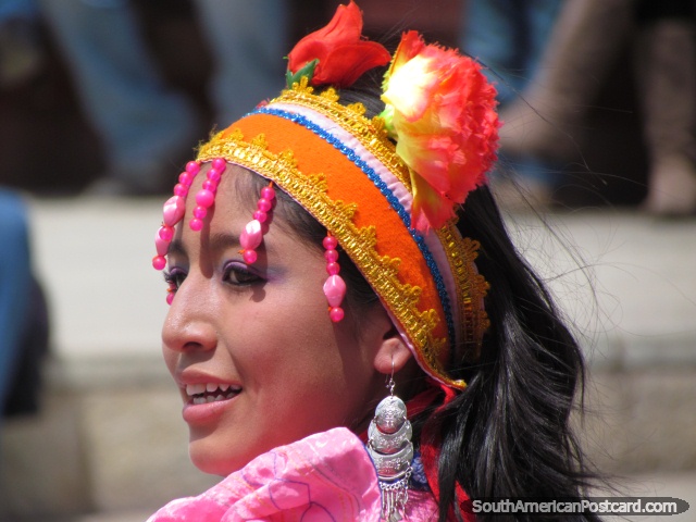 Woman with orange head band with pink beads and red flowers performs in Huaraz. (640x480px). Peru, South America.