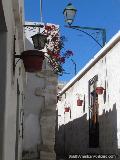 Flowerpots, red flowers, streetlamps and narrow walkways, San Lazaro in Arequipa. (480x640px). Peru, South America.